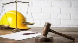 Młotek sędziowski, waga i żółty kask symbolizują, co potrzebne do pozwolenia na budowę domu.