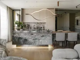 Nowoczesna kuchnia z wyspą z marmuru. Elegancka lampa zawieszona nad wyspą, tworzy idealną wysokość do przygotowywania posiłków.