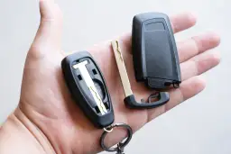 Rozłożony kluczyk samochodowy w dłoni, gotowy do złożenia. Dowiedz się, jak dorobić pilot do centralnego zamka.