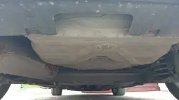 Spód Peugeot 308 SW z widocznym zbiornikiem paliwa i elementami zawieszenia. Tutaj znajdziesz instrukcję, jak wyjąć koło zapasowe.