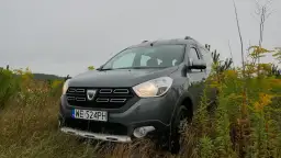 Szary Dacia Dokker na tle jesiennej przyrody. Zastanawiasz się nad jego **pojemnością baku**?