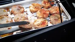 Oscypki w panierce smażone na grillu w aluminiowej tacce.