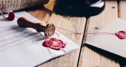 Pieczęć notarialna i dokumenty z czerwonym woskiem, symbolizujące rozporządzenie taksa notarialna.