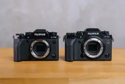 Dwa aparaty Fujifilm: X-T5 i X-T4, stojące obok siebie na drewnianym stole.