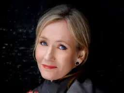 J.K. Rowling, autorka książki Harry Potter, z niebieskimi oczami i blond włosami, patrzy w obiektyw.