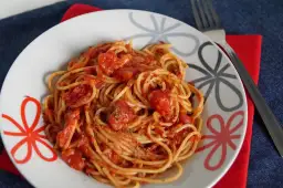 Pyszne spaghetti napoli przepis na talerzu, z sosem pomidorowym i ziołami. Idealne danie dla miłośników włoskiej kuchni.