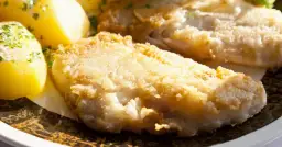 Smażona ryba w panierce z ziemniakami i natką pietruszki.