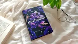 Recenzja książki "Pachnidło" Patricka Süskinda. Na zdjęciu okładka z czaszką i kwiatami, obok okulary i otwarta książka.