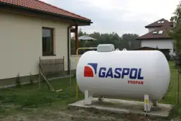 Zbiornik na gaz propan obok domu. Ogrzewanie domu gazem z butli 33 kg koszty są kluczowe dla budżetu.
