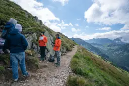 Grupa turystów na skalistej ścieżce w Tatrach. Czy trasa na Kasprowy Wierch jest trudna? Widok na góry i chmury.