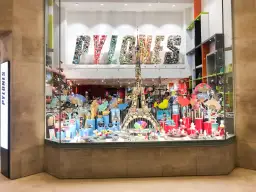 Kolorowa witryna sklepu PYLONES w Paryżu. Znajdziesz tu mnóstwo pomysłów, co kupić w Paryżu: wachlarze, wieże Eiffla, figurki i inne gadżety.