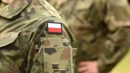 Fragment munduru wojskowego z naszywką z flagą Polski.