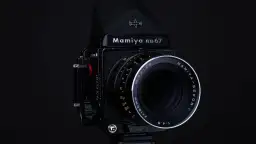 Czarny aparat Mamiya RB67 z obiektywem Mamiya-Sekor C f=180mm. Idealny do zdjęć, które wymagają precyzji i jakości, jaka klisza do aparatu jest w stanie zapewnić.