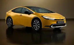 Nowy Toyota Prius V generacji w kolorze złotym, z czarnym dachem, na tle studyjnym.