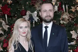 Para z uśmiechem na tle choinki.