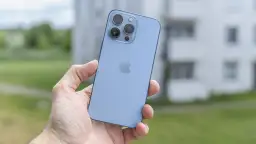 Niebieski iPhone 13 Pro z potrójnym aparatem w dłoni, gotowy do uchwycenia pięknych chwil.