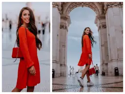 Elegancka, czerwona sukienka i torebka tworzą idealną stylizację na uroczystość rodzinną. Kobieta w ruchu pod łukiem.