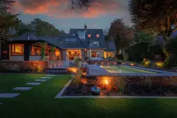 Piękny dom z basenem i tarasem, oświetlony ciepłym światłem. Oświetlenie z akumulatora na działce tworzy magiczną atmosferę wieczorem.