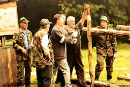 Grupa mężczyzn w strojach myśliwskich buduje drewnianą konstrukcję. Czy myśliwy ma obowiązek wykonać prace na rzecz koła?