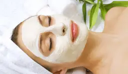 Kobieta z maseczką na twarzy, która zapewnia okluzję w kosmetyce, poprawiając wchłanianie składników. Relaks i pielęgnacja.