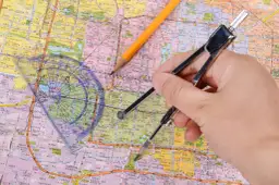 Jak wytłumaczyć dziecku skalę? Cyrkiel i ołówek na mapie pomagają zrozumieć proporcje i odległości.
