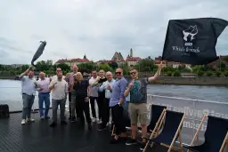 Grupa mężczyzn świętuje na statku, unosząc kieliszki. Czy warto inwestować w whisky kolekcjonerską? Portfel inwestycyjny 2026.