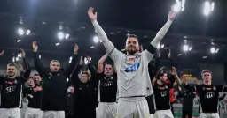 Piłkarze świętują zwycięstwo, podnosząc ręce do góry. Ich radość pokazuje, jak dostać się do ekstraklasy.