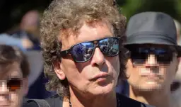 Wokalista Lady Pank w okularach przeciwsłonecznych, w tle tłum ludzi.