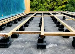 Drewniana konstrukcja tarasu na papie, gotowa na deski. To idealny fundament, na którym można położyć papę na tarasie, a potem deski kompozytowe lub drewniane.