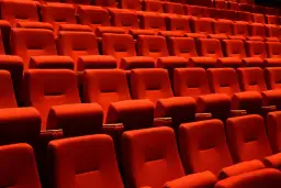 Czerwone fotele kinowe, idealne do oglądania filmów. Które miejsca w teatrze są najlepsze? Te z najlepszym widokiem i dźwiękiem!