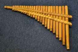 Drewniana fletnia pana instrument, wykonana z bambusowych rurek o różnej długości, związanych sznurkiem.
