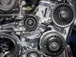 Zbliżenie na mechanizm silnika samochodowego z paskami i kołami pasowymi.