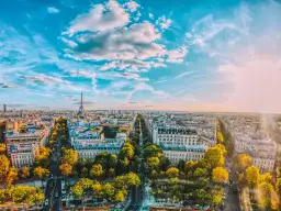 Widok na Paryż z wieżą Eiffla w oddali. Czy Paryż jest niebezpieczny? Miasto tętni życiem, a jesienne drzewa dodają mu uroku.