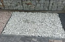 Jasnoszary grys idealny na podjazd. Obok kamienie w kolorze różowym i ciemnoszarym.