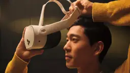 Mężczyzna w żółtym swetrze zakłada gogle VR. Zastanawiasz się, ile kosztuje zestaw VR?