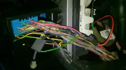 Plątanina przewodów w Opel Meriva, widoczny niebieski konektor i fragmenty instalacji elektrycznej, być może związane z lokalizacją bezpieczników.