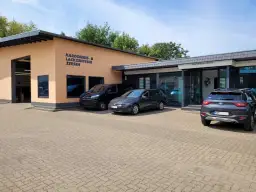 Gebäude des Karosserie- & Lackzentrums Zeesen mit Autos davor.