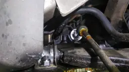 Zbliżenie na element układu kierowniczego samochodu, widoczny przegub i metalowe elementy.