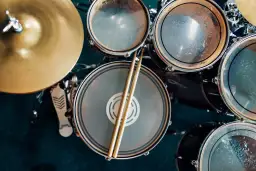 Pałeczki spoczywają na werblu, gotowe do rytmicznej gry na perkusji.