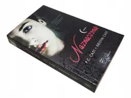 Recenzja książki "Naznaczona" P.C. Cast i Kristin Cast. Okładka z tajemniczą twarzą i motywami wampirów.