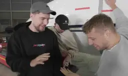 Trzech mężczyzn, w tym MrBeast, stoi obok samolotu. Pytanie "czy Mister Beast żyje" jest nieaktualne, bo widać go w świetnej formie!
