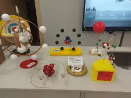 Modele atomów wykonane z różnych materiałów, w tym kulek, drutu i pianki.