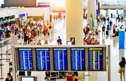 Lotnisko pełne ludzi, tablice odlotów. Chcesz wiedzieć, jak szukać tanich lotów? Blog podpowie!