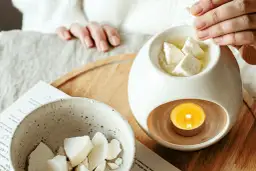 Wosk sojowy do kominka topi się w ceramicznym kominku, tworząc przytulną atmosferę.