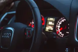 Widok na deskę rozdzielczą samochodu Audi z kierownicą i wskaźnikami.