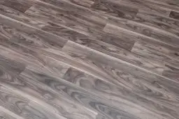 Szare linoleum na balkon, imitujące drewno, z widocznym usłojeniem. Idealne do stworzenia przytulnej przestrzeni.