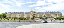 Imponujący budynek z kopułą, plac Inwalidów w Paryżu, z armatami i zadbanym ogrodem.