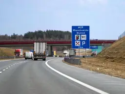 Znak MOP Wierzchowisko Wschód informuje o miejscu obsługi podróżnych z toaletą i parkingiem za 2 km.