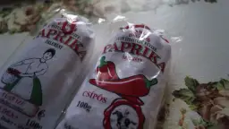 Dwie paczki mielonej papryki z Węgier, jedna z rysunkiem kobiety z koszykiem, druga z papryczką.