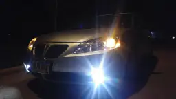 Złoty samochód nocą, włączone światła mijania i przeciwmgielne. Dowiedz się, jak włączyć światła przeciwmgielne, by poprawić widoczność.